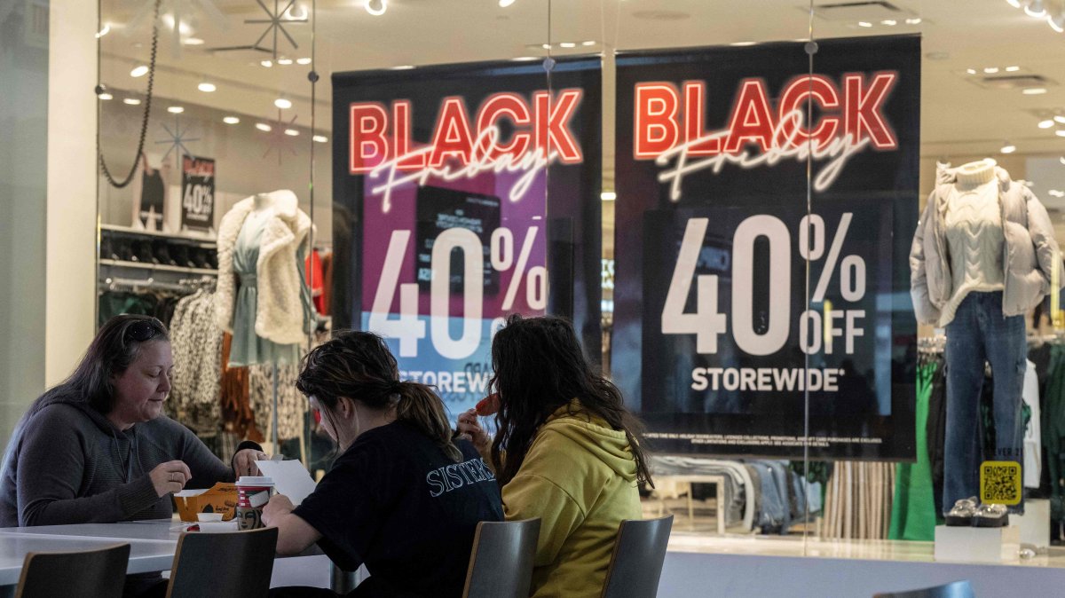 A family eats lunch near a store advertising a Black Friday sale at the Pentagon City Mall in Arlington, Virginia, U.S., Nov. 22, 2023. (AFP Photo)