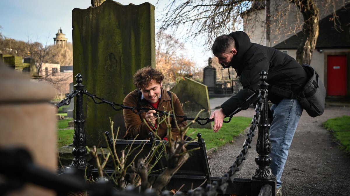 Invisible Cities guide Sonny Murray (R) leads a walking tour with student Arthur Lyhne-Gold in Canongate Kirk, Edinburgh, Scotland, U.K., Nov. 17, 2024. (AFP Photo)