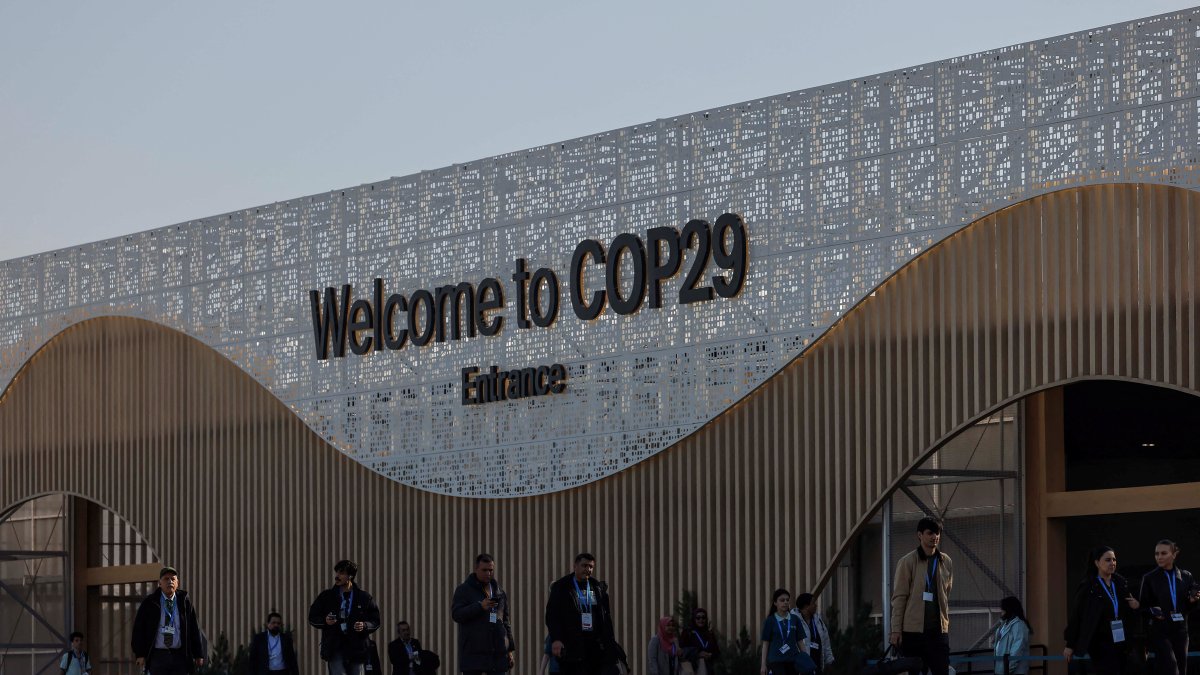 People walk next to the COP29 United Nations climate change conference pavilion, in Baku, Azerbaijan, Nov. 22, 2024. (Reuters Photo)