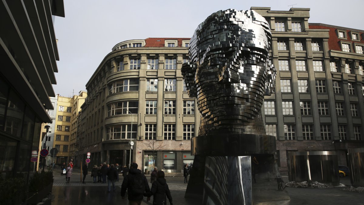 Tourists walk past a moving metal sculpture of writer Franz Kafka in his birth city of Prague, Czechia, Feb. 4, 2017. (AP Photo)