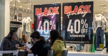 A family eats lunch near a store advertising a Black Friday sale at the Pentagon City Mall in Arlington, Virginia, U.S., Nov. 22, 2023. (AFP Photo)