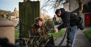 Invisible Cities guide Sonny Murray (R) leads a walking tour with student Arthur Lyhne-Gold in Canongate Kirk, Edinburgh, Scotland, U.K., Nov. 17, 2024. (AFP Photo)