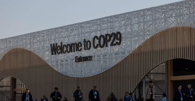 People walk next to the COP29 United Nations climate change conference pavilion, in Baku, Azerbaijan, Nov. 22, 2024. (Reuters Photo)