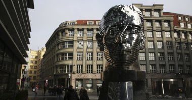 Tourists walk past a moving metal sculpture of writer Franz Kafka in his birth city of Prague, Czechia, Feb. 4, 2017. (AP Photo)