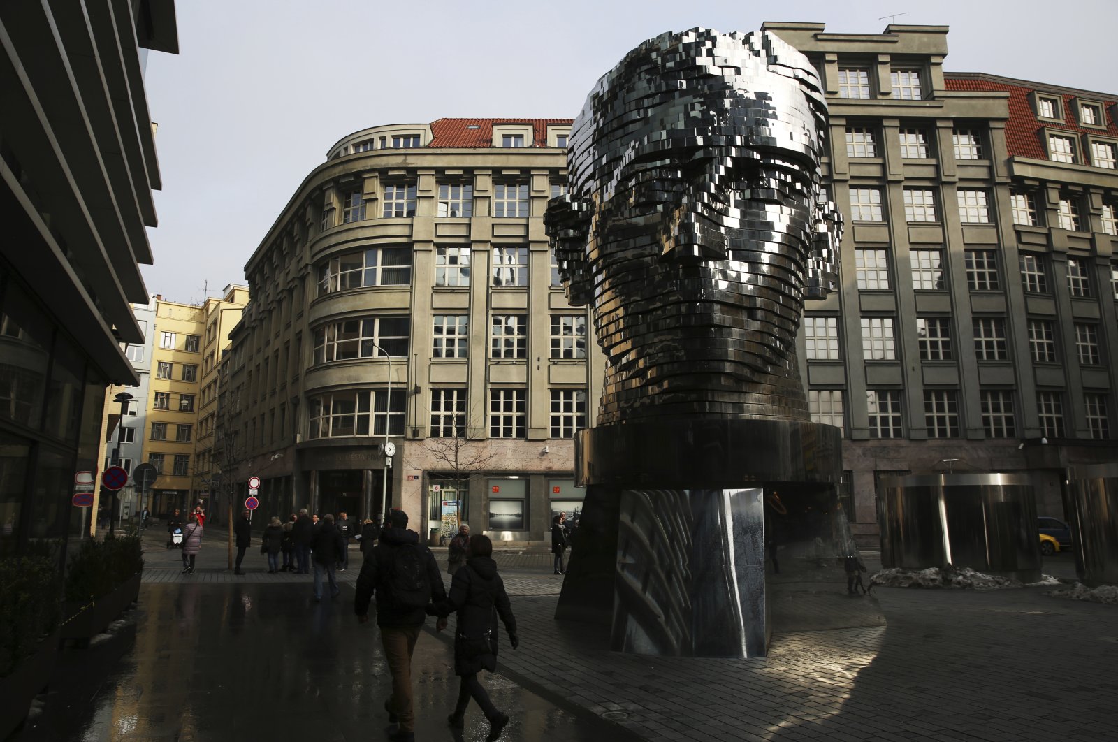 Tourists walk past a moving metal sculpture of writer Franz Kafka in his birth city of Prague, Czechia, Feb. 4, 2017. (AP Photo)