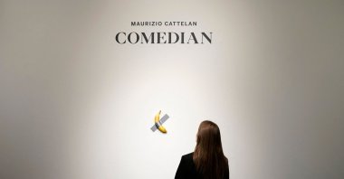 A woman looks at Italian visual artist Maurizio Cattelan’s duct-taped Banana entitled &quot;Comedian,&quot; during a press preview at Sotheby&#039;s in New York, U.S., Oct. 25, 2024. (AFP Photo)