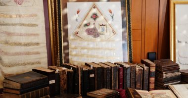 A historic photo album and abstract composition are seen among the rare works set for auction, Istanbul, Türkiye, Nov. 24, 2024. (AA Photo)