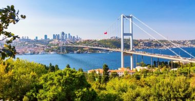 The Bosphorus Bridge, officially known as the 15 July Martyrs Bridge, with Istanbul&#039;s panoramic cityscape on a sunny summer day in Istanbul, Türkiye. (Shutterstock)