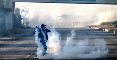 A member of jailed former prime minister Imran Khan&#039;s Pakistan Tehreek-e-Insaf (PTI) party attempts to throw back teargas shells fired by riot policemen as they protest during a march to Islamabad demanding Khan&#039;s release, Punjab province, Pakistan, Nov. 25, 2024. (AFP Photo)