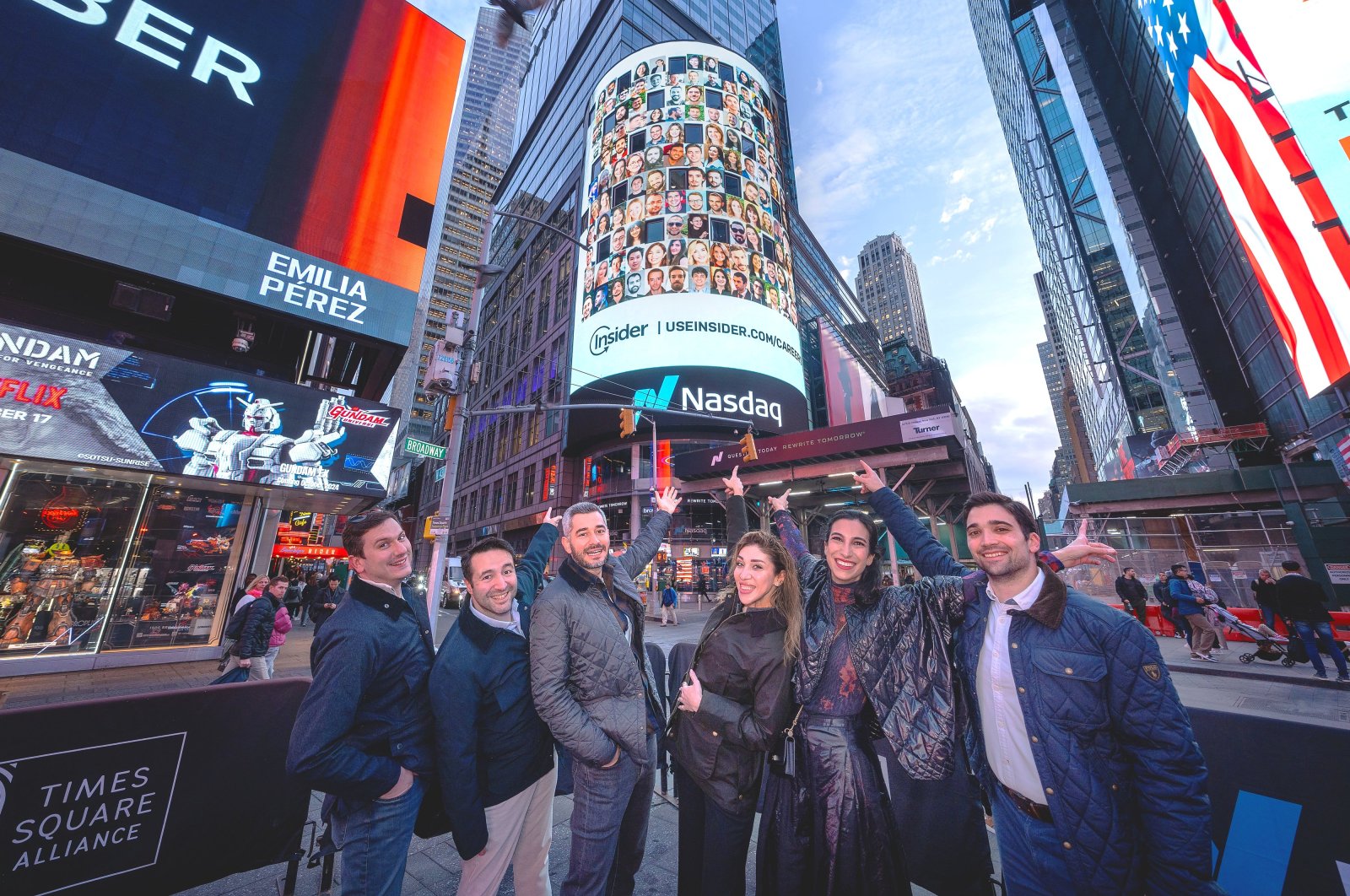 Hande Çilingir (C), co-founder and CEO of Insider, and other Insider team members pose in front of the Nasdaq digital billboard in Times Square in New York, U.S. (Photo: @HandeCilingir)