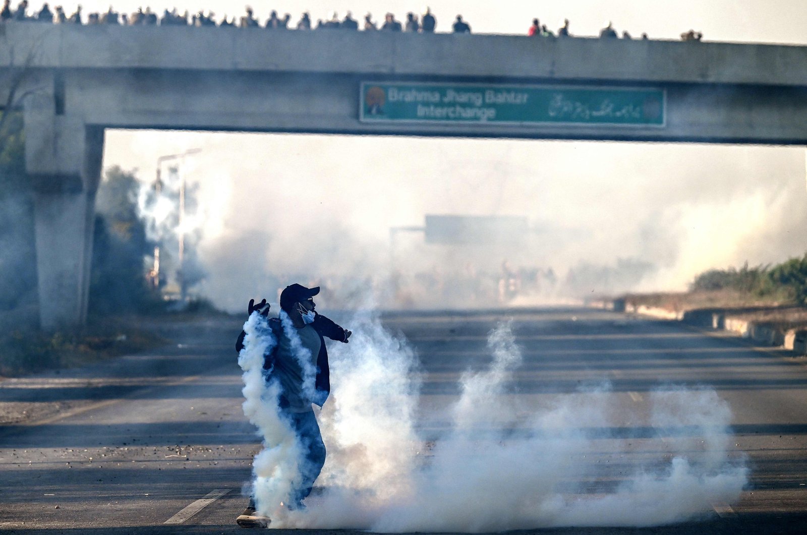 A member of jailed former prime minister Imran Khan&#039;s Pakistan Tehreek-e-Insaf (PTI) party attempts to throw back teargas shells fired by riot policemen as they protest during a march to Islamabad demanding Khan&#039;s release, Punjab province, Pakistan, Nov. 25, 2024. (AFP Photo)