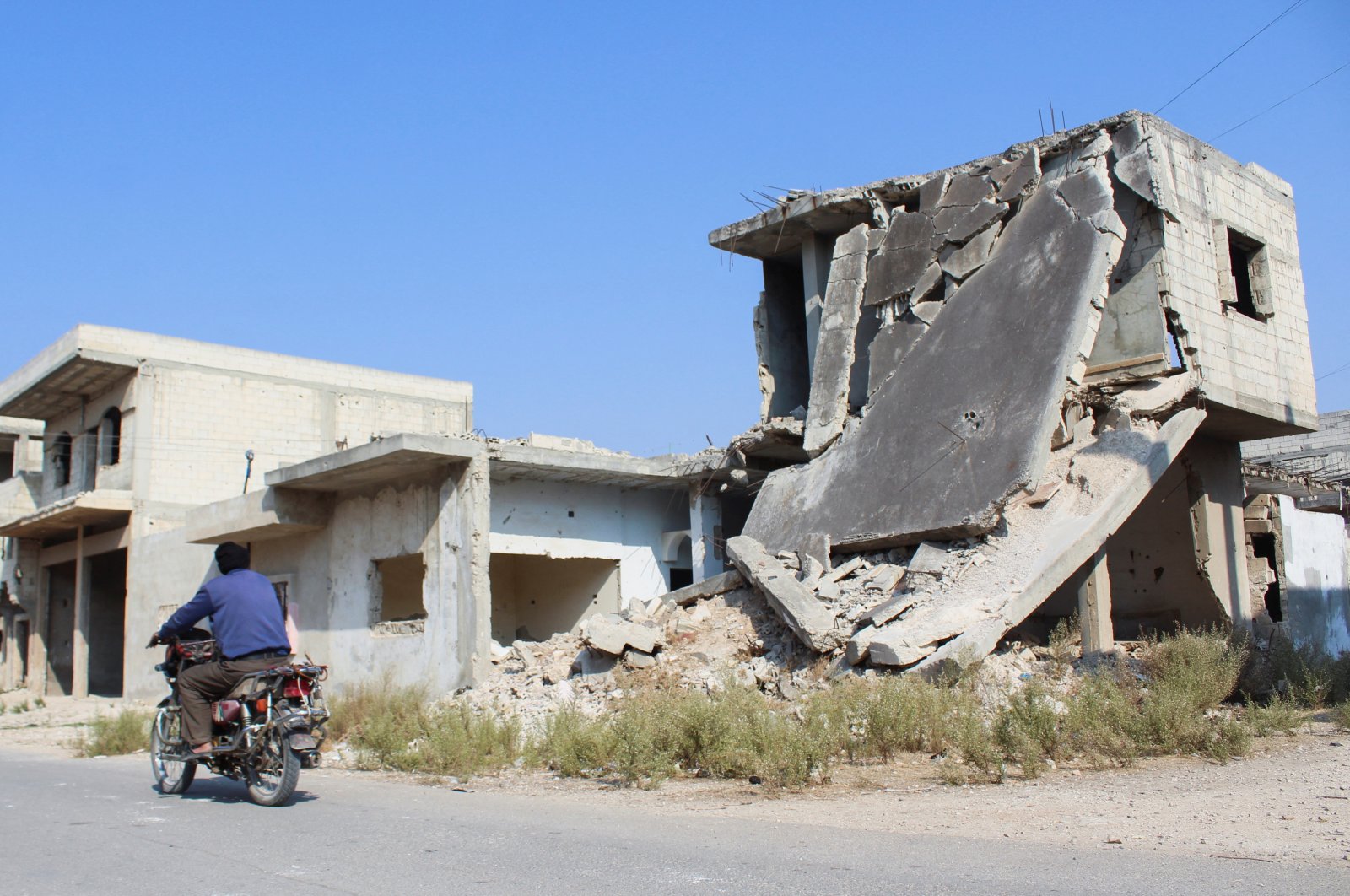 A man rides a motorbike past a damaged building in Homs, Syria Nov. 7, 2024. (Reuters File Photo)