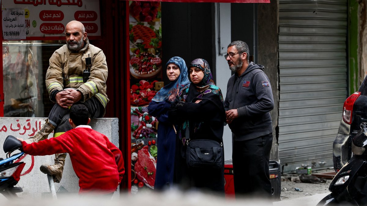 A civil defense member and people stand near a damaged site in the aftermath of Israeli strikes, Beirut, Lebanon, Nov. 25, 2024. (Reuters Photo)