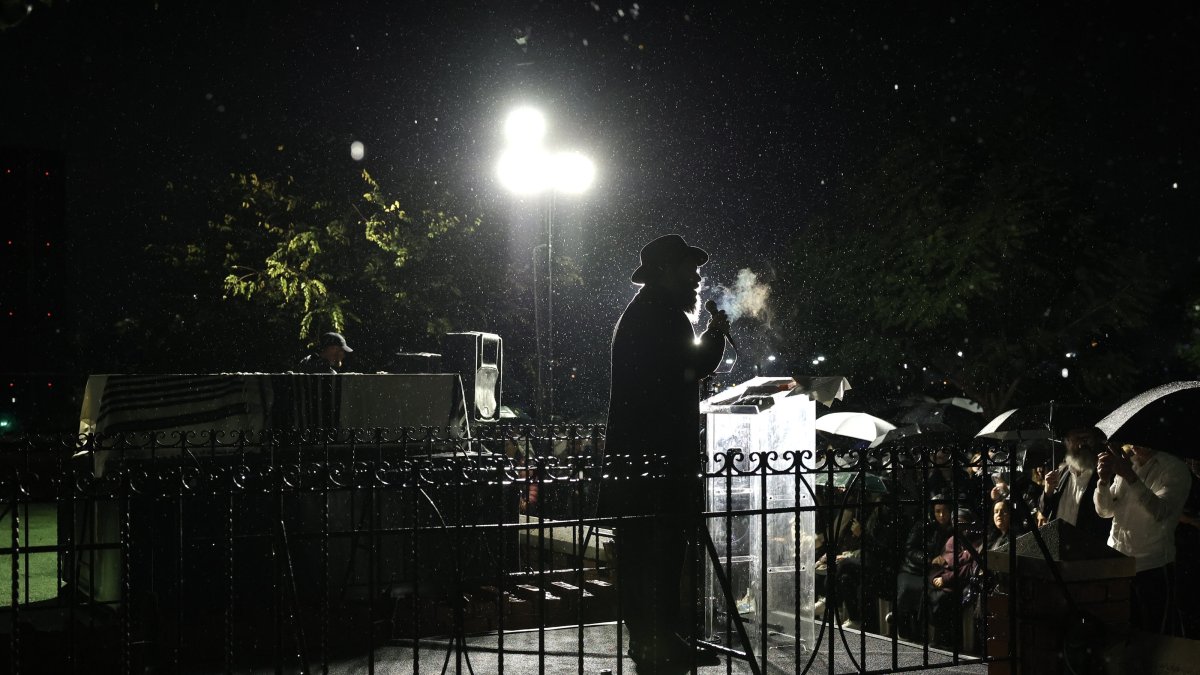 An Ultra-Orthodox Jewish Rabbi speaks beside the coffin of murdered Rabbi Zvi Kogan as rain falls during his funeral ceremony, in Kfar Chabad, near Tel Aviv, Israel,  Nov. 25, 2024. (EPA Photo)