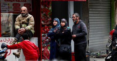 A civil defense member and people stand near a damaged site in the aftermath of Israeli strikes, Beirut, Lebanon, Nov. 25, 2024. (Reuters Photo)