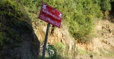 A sign reading "Warning, prohibited area - Land mines - Danger" alongside a road in Mantong town, northern Shan State, Myanmar, Nov. 17, 2024. (AFP Photo)