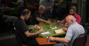 A group of men play a Rummikub game locally called "Okey" at Kadiköy neighborhood, Istanbul, Türkiye, Sept. 27, 2023. (AP Photo)