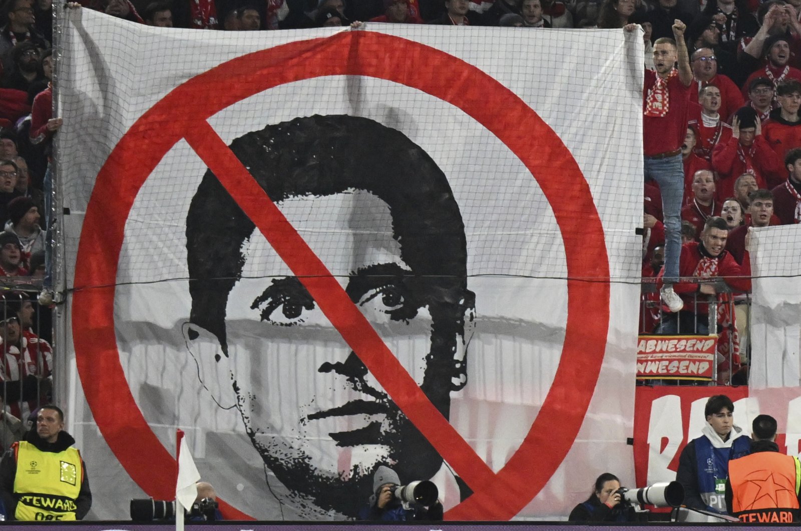 Munich fans hold up a banner against Nasser Al-Khelaifi, president of Paris Saint-Germain during the match between FC Bayern and Paris Saint Germain, at the Allianz Arena, Munich, Germany, Nov. 26, 2024. (AP Photo)