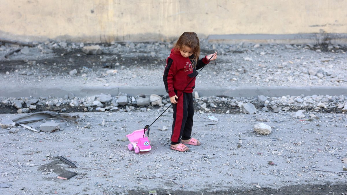 A Palestinian girl pull on her toy on a debris-filled street in Jabalia, northern Gaza, Palestine, Nov. 20, 2024. (AFP Photo)