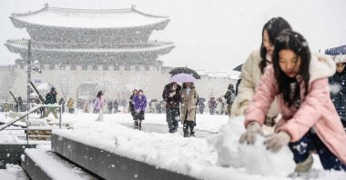Pedestrians walk in front of the Gyeongbokgung Palace amid heavy snowfall in central Seoul, South Korea, Nov. 27, 2024. (AFP Photo)