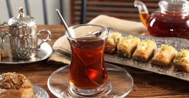 Turkish tea and sweets are served in a vintage tea set on a wooden table. (Shutterstock)