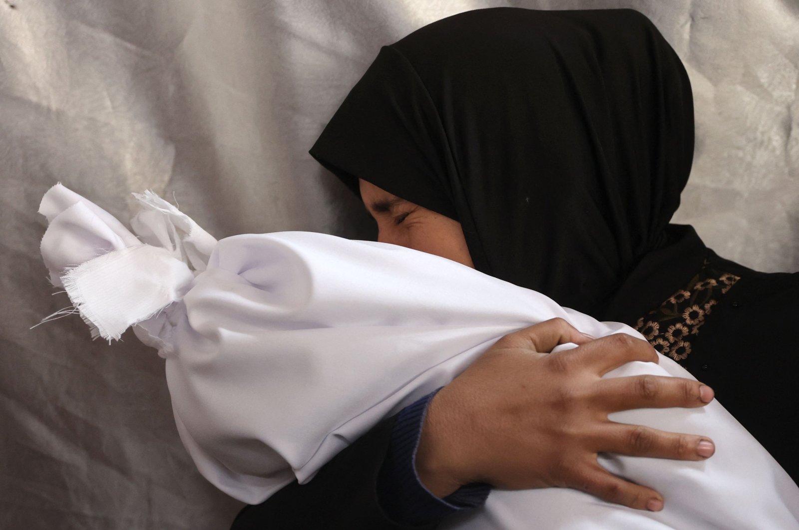 A Palestinian woman mourns as she holds the body of a relative killed in an Israeli strike at Al-Ahli Arab Hospital, also known as the Baptist Hospital, Gaza City, Palestine, Nov. 27, 2024. (AFP Photo)