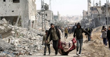 Palestinian men carry a body retrieved from under the rubble following their return to Nuseirat after Israeli shelling of the camp stopped, central Gaza Strip, Palestine, Nov. 29, 2024. (AFP Photo)