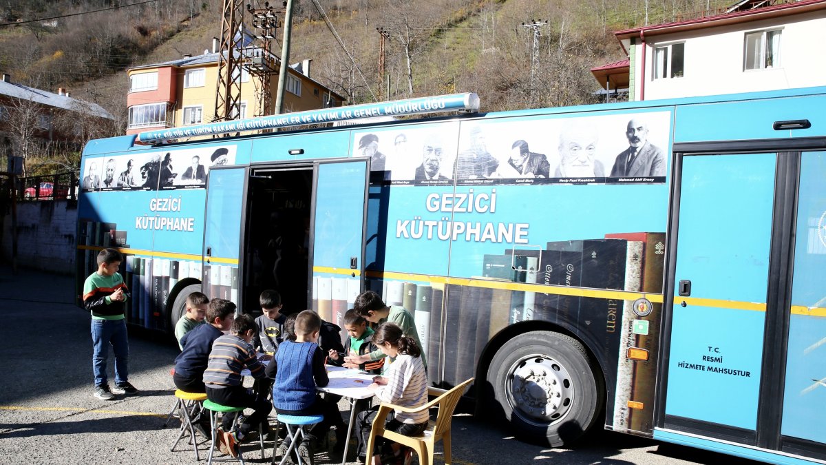 Children enjoy reading books in front of the Mobile Library Bus, Giresun, Türkiye, Dec. 1, 2024. (AA Photo)