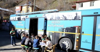 Children enjoy reading books in front of the Mobile Library Bus, Giresun, Türkiye, Dec. 1, 2024. (AA Photo)