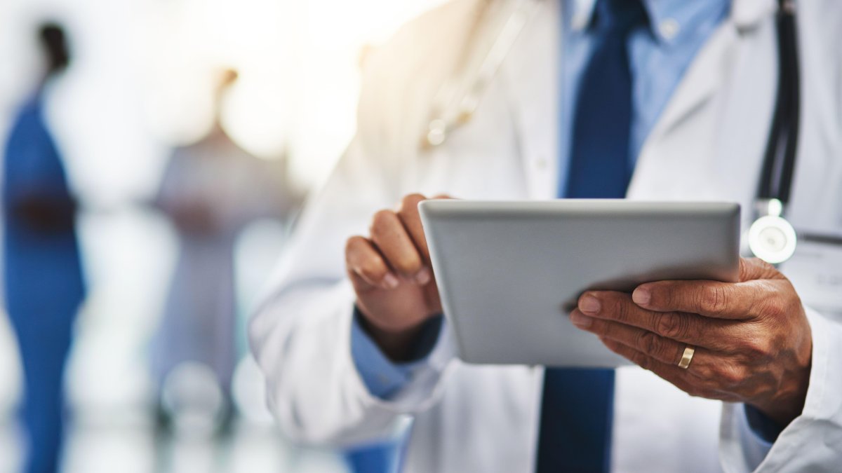 This cropped shot shows a doctor using a digital tablet with his colleagues in the background. (Reuters Photo)