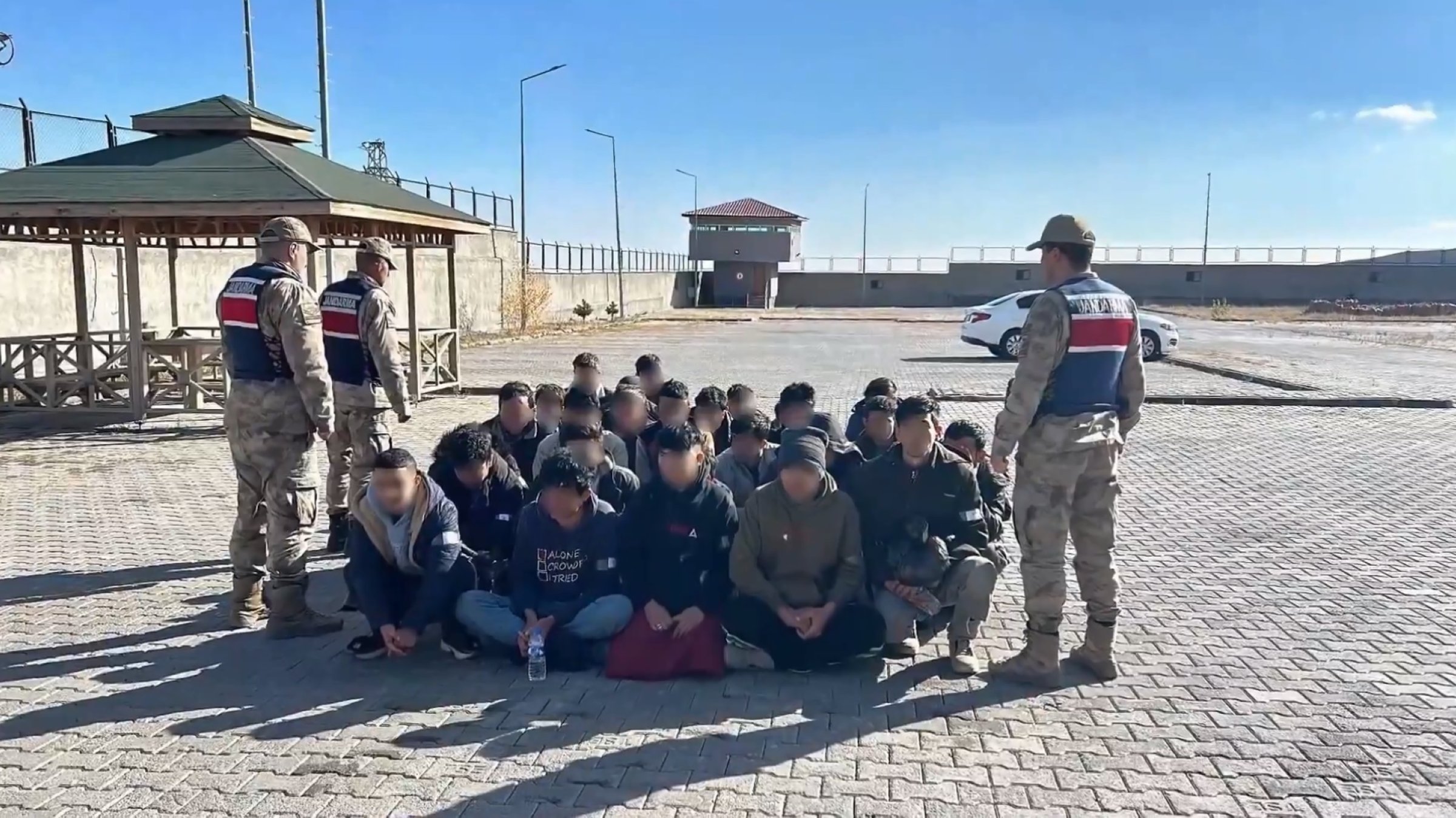 Gendarmerie officers stand guard over a group of migrant smugglers caught in the capital of Ankara, Türkiye, Dec. 1, 2024. (DHA Photo)