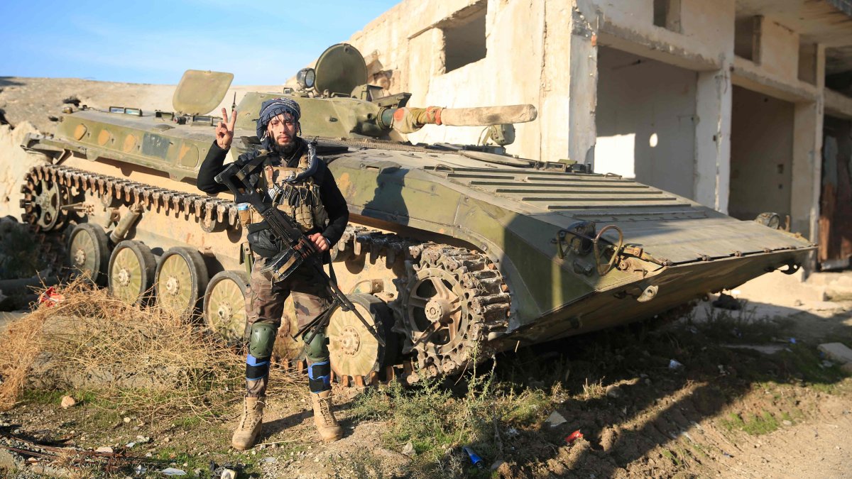 An opposition fighter poses next to an armored carrier in Tal Rifaat, northern Syria, Dec. 2, 2024. (AFP Photo)