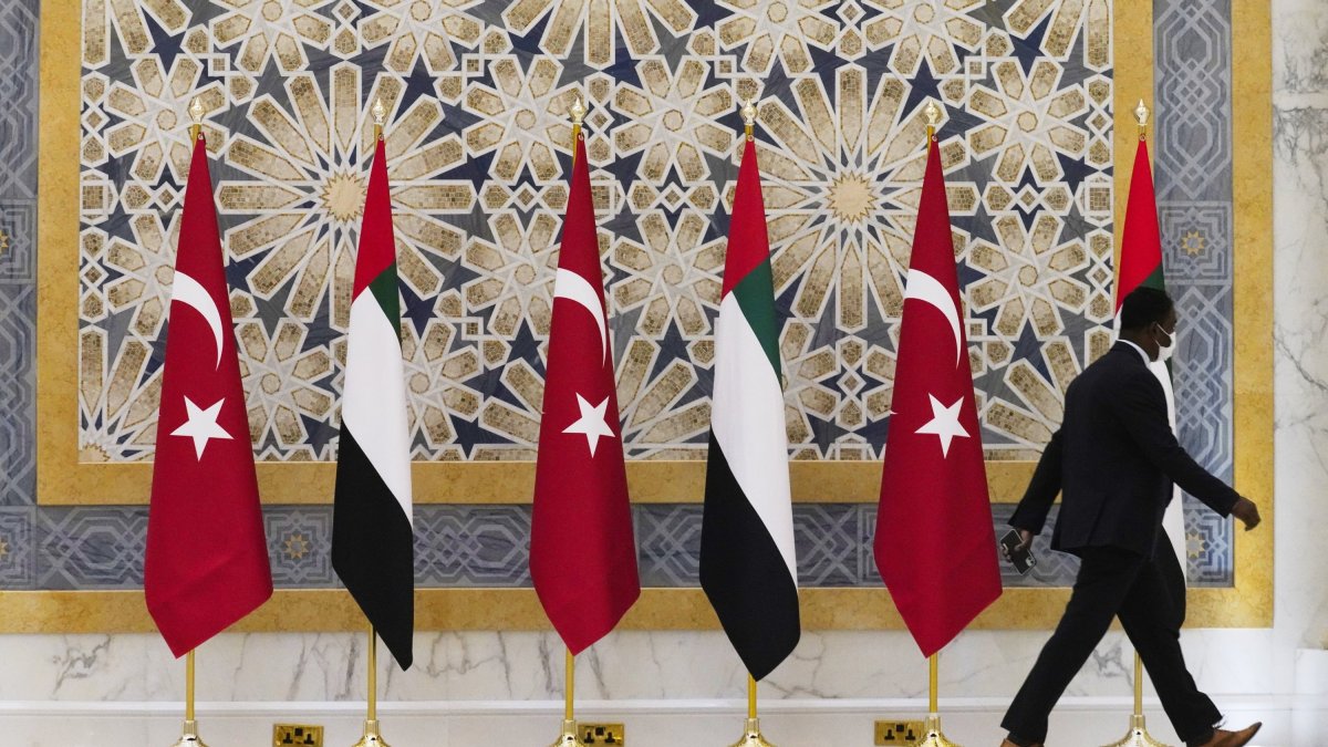 An official walks past Turkish and Emirati flags at Qasr Al-Watan in Abu Dhabi, United Arab Emirates, Monday, Feb. 14, 2022. (AP File Photo)