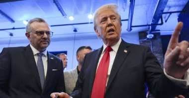 Former President Donald Trump signs autographs as Massad Boulos listens during a visit to The Great Commoner, in Dearborn, Michigan, U.S., Nov. 1, 2024. (AP Photo)