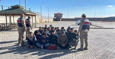 Gendarmerie officers stand guard over a group of migrant smugglers caught in the capital of Ankara, Türkiye, Dec. 1, 2024. (DHA Photo)