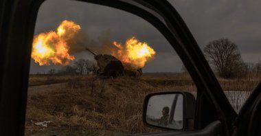 A Ukrainian soldier reflected in a car mirror looks on as a Swedish-made Archer Howitzer operated by the 45th Artillery Brigade fires toward Russian positions, Donetsk region, Ukraine, Jan. 20, 2024. (AFP Photo)
