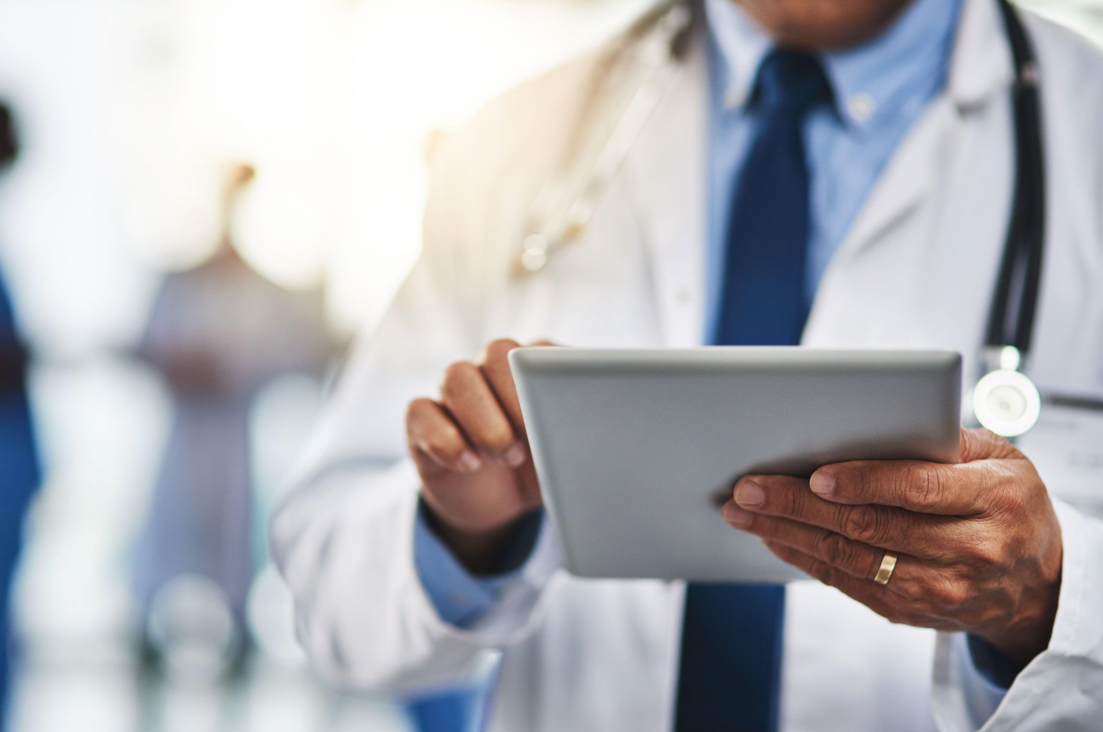 This cropped shot shows a doctor using a digital tablet with his colleagues in the background. (Reuters Photo)