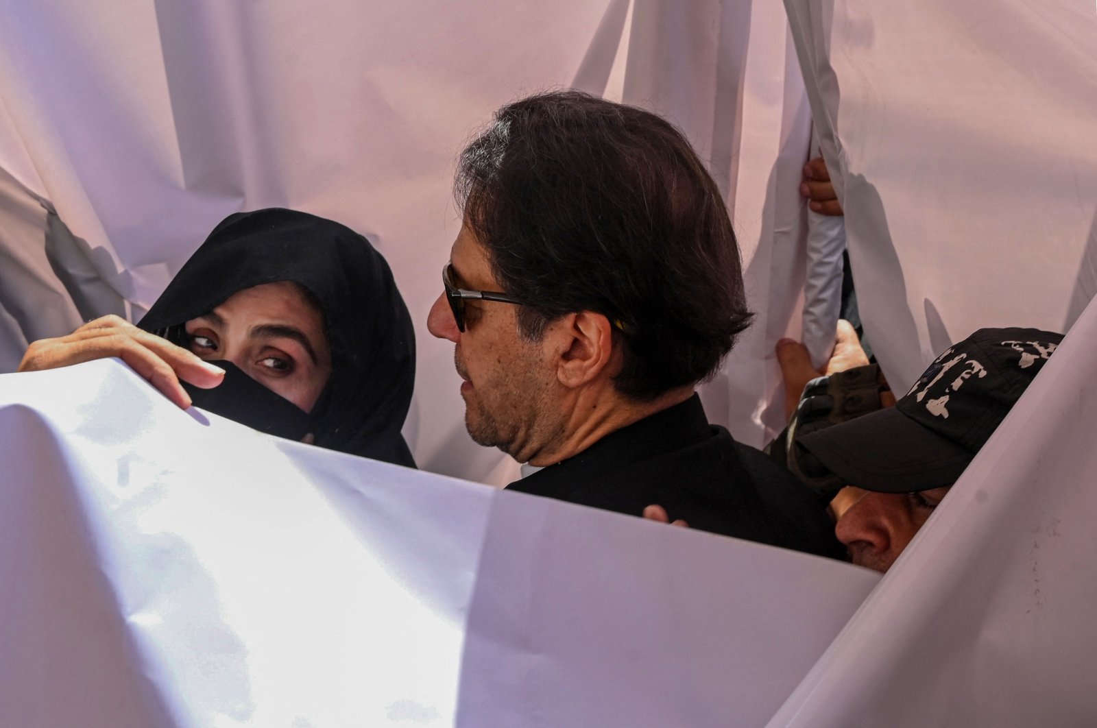 Former Pakistan Prime Minister Imran Khan (C) with his wife Bushra Bibi (L) arrive to appear at a high court in Lahore, Pakistan, May 15, 2023. (AFP Photo)