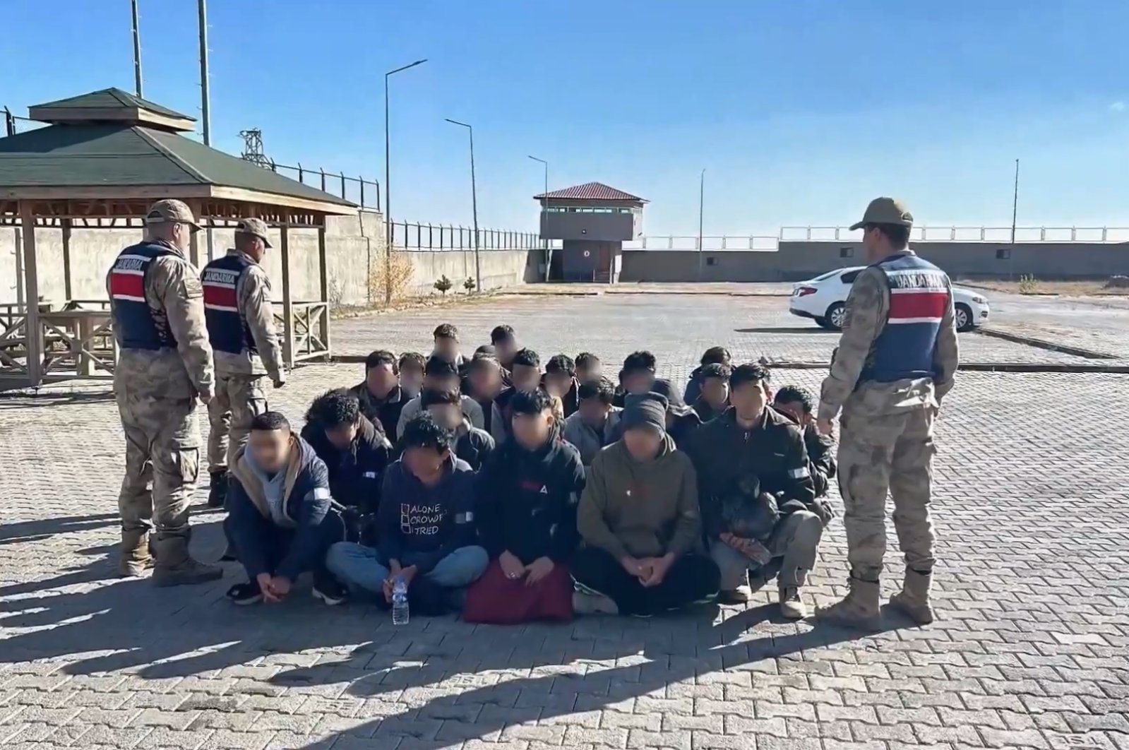 Gendarmerie officers stand guard over a group of migrant smugglers caught in the capital of Ankara, Türkiye, Dec. 1, 2024. (DHA Photo)