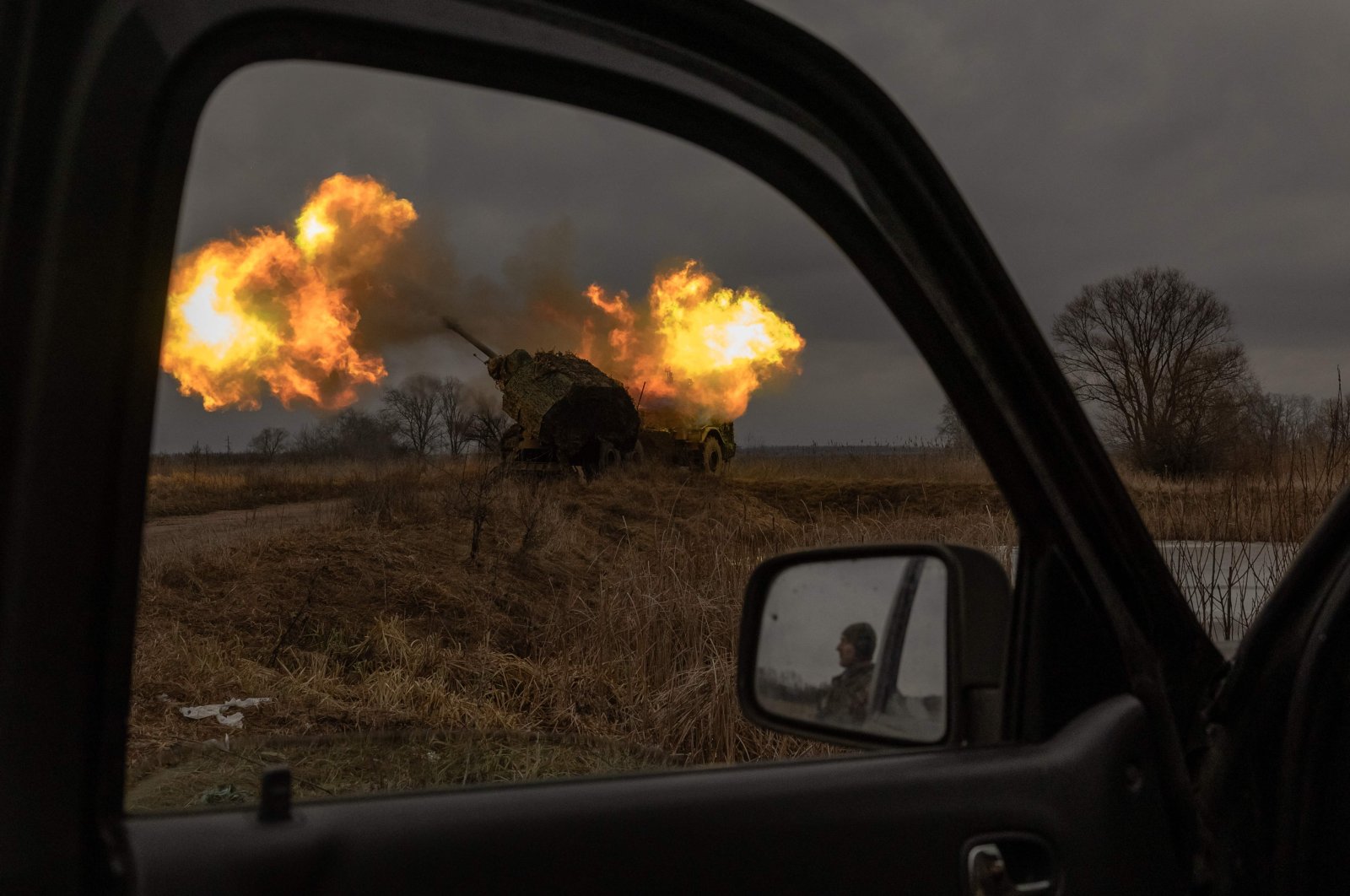 A Ukrainian soldier reflected in a car mirror looks on as a Swedish-made Archer Howitzer operated by the 45th Artillery Brigade fires toward Russian positions, Donetsk region, Ukraine, Jan. 20, 2024. (AFP Photo)