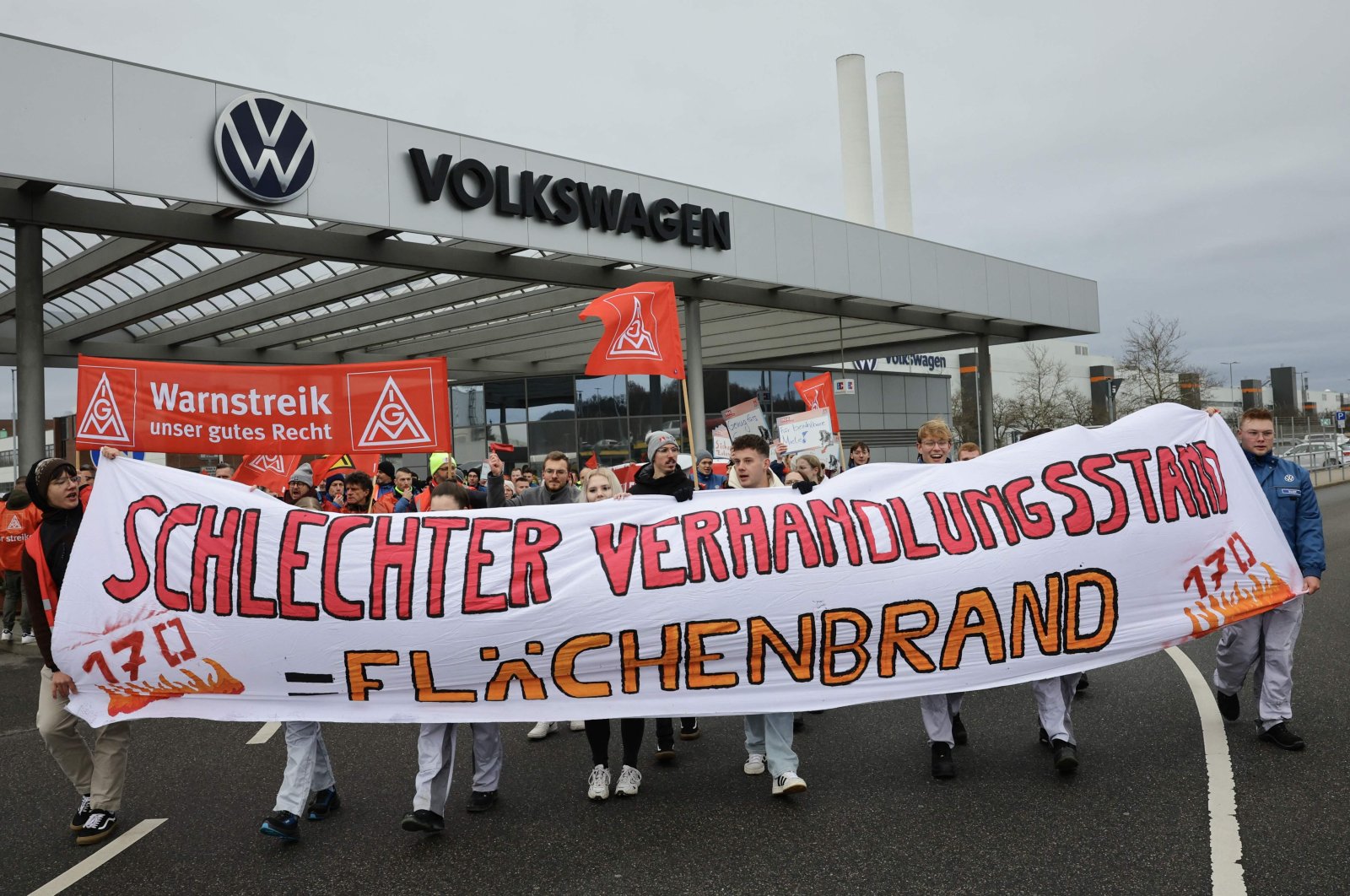 Employees of Volkswagen demonstrate with a banner of IG Metall union reading "Poor state of negotiations equals wildfire" in front of the VW plant in Zwickau, Germany, Dec. 2, 2024. (AFP Photo)