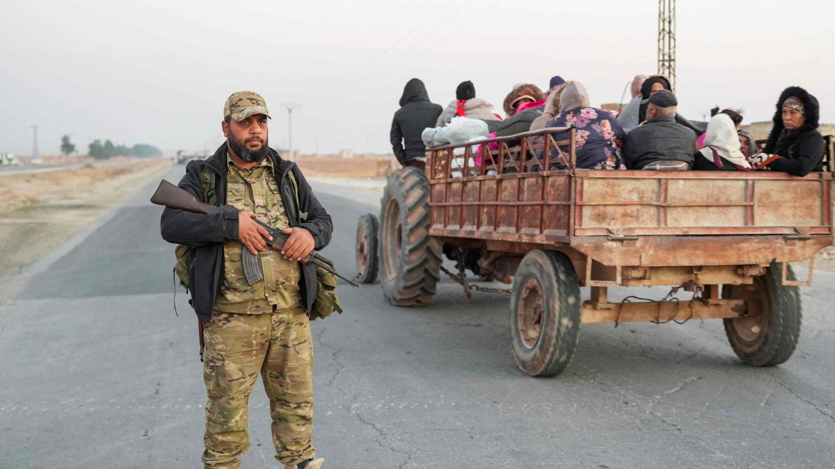 An anti-regime fighter stands on a road as Syrian Kurds flee areas on the outskirts of the northern city of Aleppo, which was formerly controlled by the PKK/YPG terrorist group, after they were seized by armed opposition groups, Syria, Dec. 2, 2024. (AFP Photo)