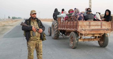 An anti-regime fighter stands on a road as Syrian Kurds flee areas on the outskirts of the northern city of Aleppo, which was formerly controlled by the PKK/YPG terrorist group, after they were seized by armed opposition groups, Syria, Dec. 2, 2024. (AFP Photo)