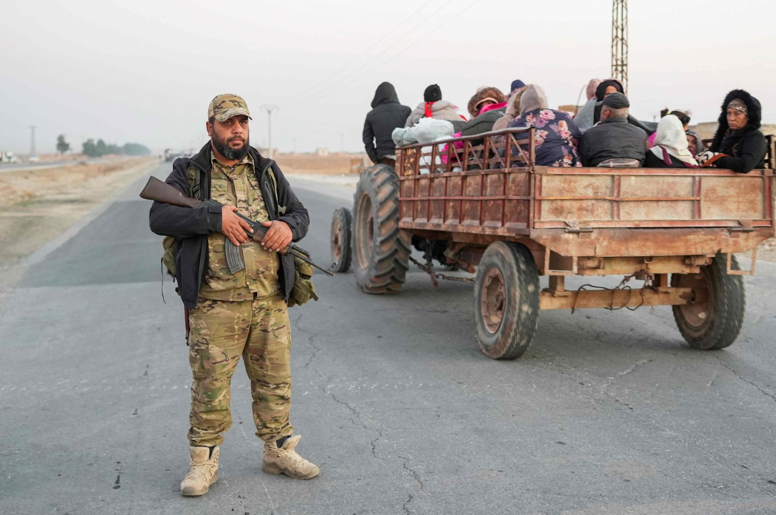 An anti-regime fighter stands on a road as Syrian Kurds flee areas on the outskirts of the northern city of Aleppo, which was formerly controlled by the PKK/YPG terrorist group, after they were seized by armed opposition groups, Syria, Dec. 2, 2024. (AFP Photo)