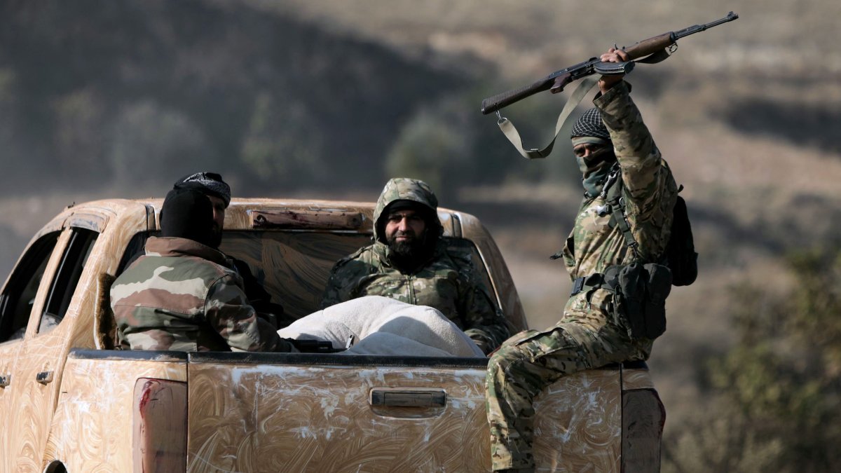 Anti-regime fighters ride in the back of a pickup truck in the town of Suran, between Aleppo and Hama, Syria, Dec. 3, 2024. (AFP Photo)