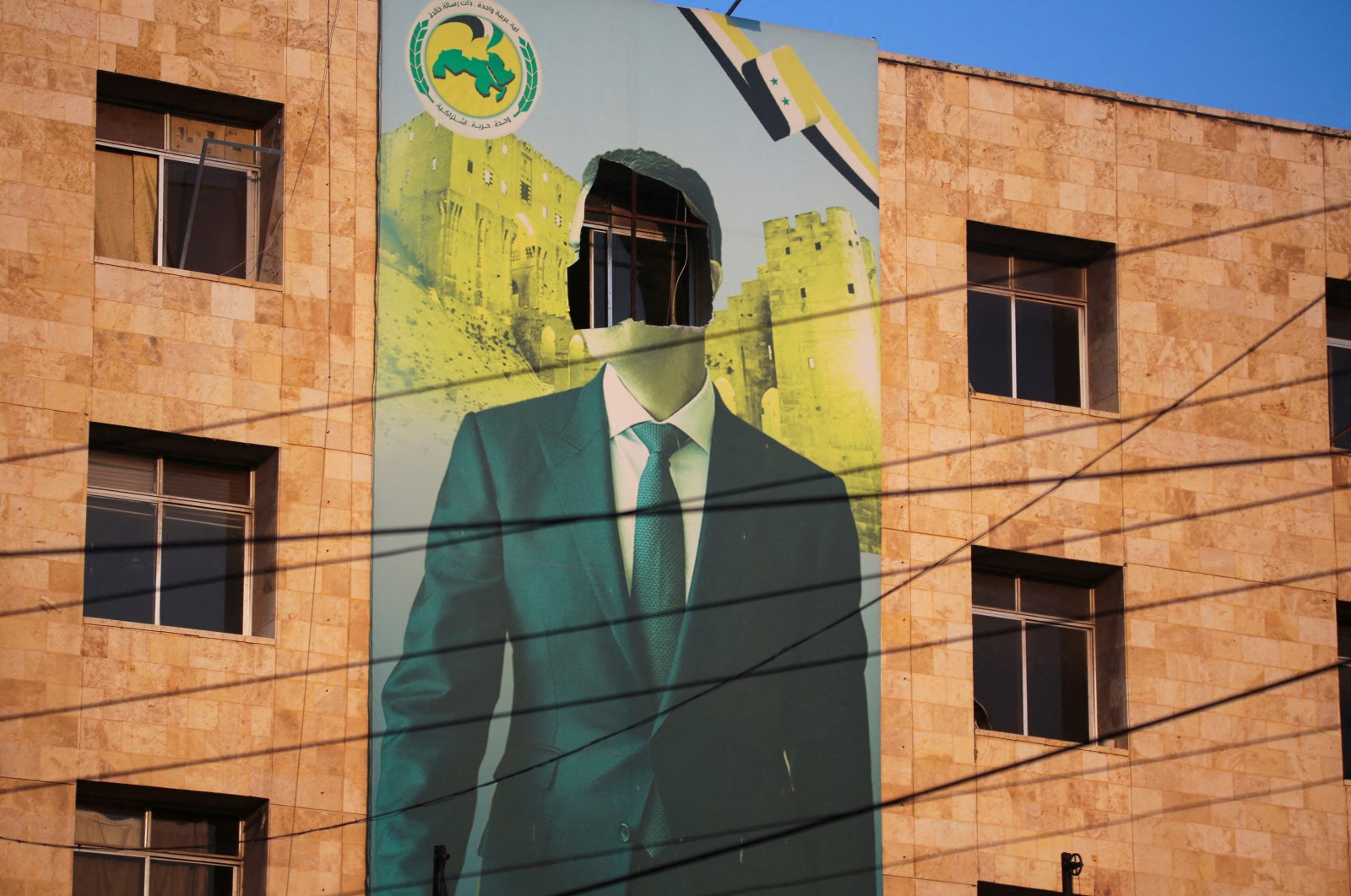 A view shows a damaged poster of Syrian regime leader Bashar Assad in Aleppo, after the Syrian army said that dozens of its soldiers had been killed in a major attack by anti-regime fighters who swept into the city, Aleppo, Syria, Nov. 30, 2024. (Reuters Photo)