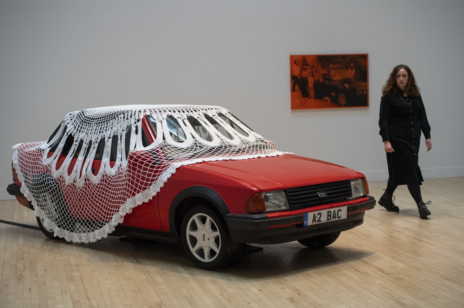 A woman walks past an artwork by Jasleen Kaur during the Turner Prize 2024 press preview at Tate Britain, London, Tuesday, Sept. 24, 2024. (AP Photo)