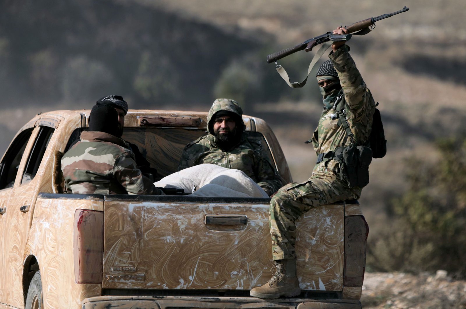 Anti-regime fighters ride in the back of a pickup truck in the town of Suran, between Aleppo and Hama, Syria, Dec. 3, 2024. (AFP Photo)