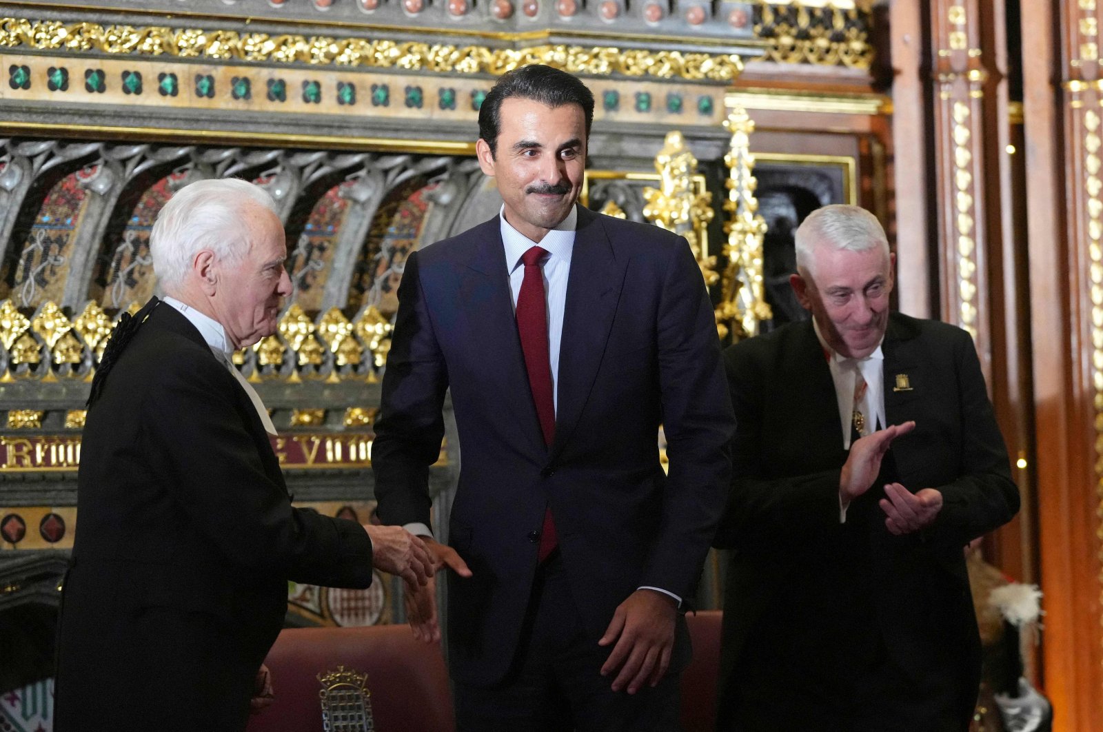 Qatar&#039;s Emir Sheikh Tamim bin Hamad Al Thani (C) is applauded by Speaker of the House of Commons Lindsay Hoyle (R) and Speaker of the House of Lords John McFall during a visit to the Palace of Westminster in London, U.K., Dec. 3, 2024. (AFP Photo)