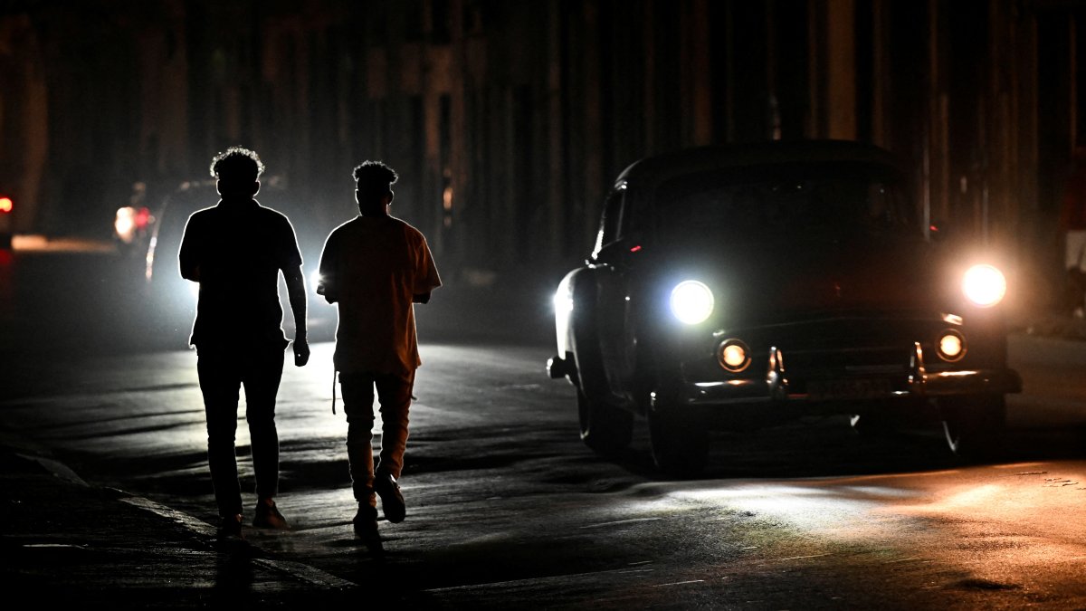 People walk at night on a street during a nationwide blackout caused by a grid failure in Havana, Cuba, Dec. 4, 2024. (AFP Photo)